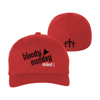 image of the front and back of a red flexfit hat on a white background. front is on the left and has a black print in the center that says bloody sunday. white below says violent j. back is on the right and has a bottom center print in black of three crosses