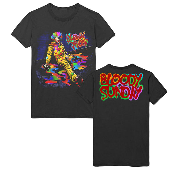 image of the front and back of a black tee shirt on a white background. front is on the left and has a full body print of the clown blood album cover of a clown sitting on a floor with rainbow blood. the back has a print across the shoulders that says bloody sunday