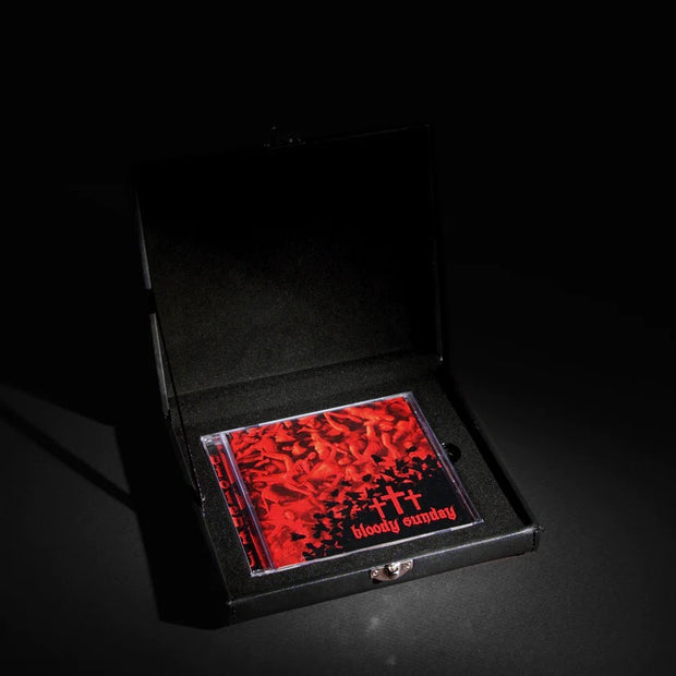 image of a jewel case c d in an open case. cover has red bodies and three red crosses and says bloody sunday on the bottom right